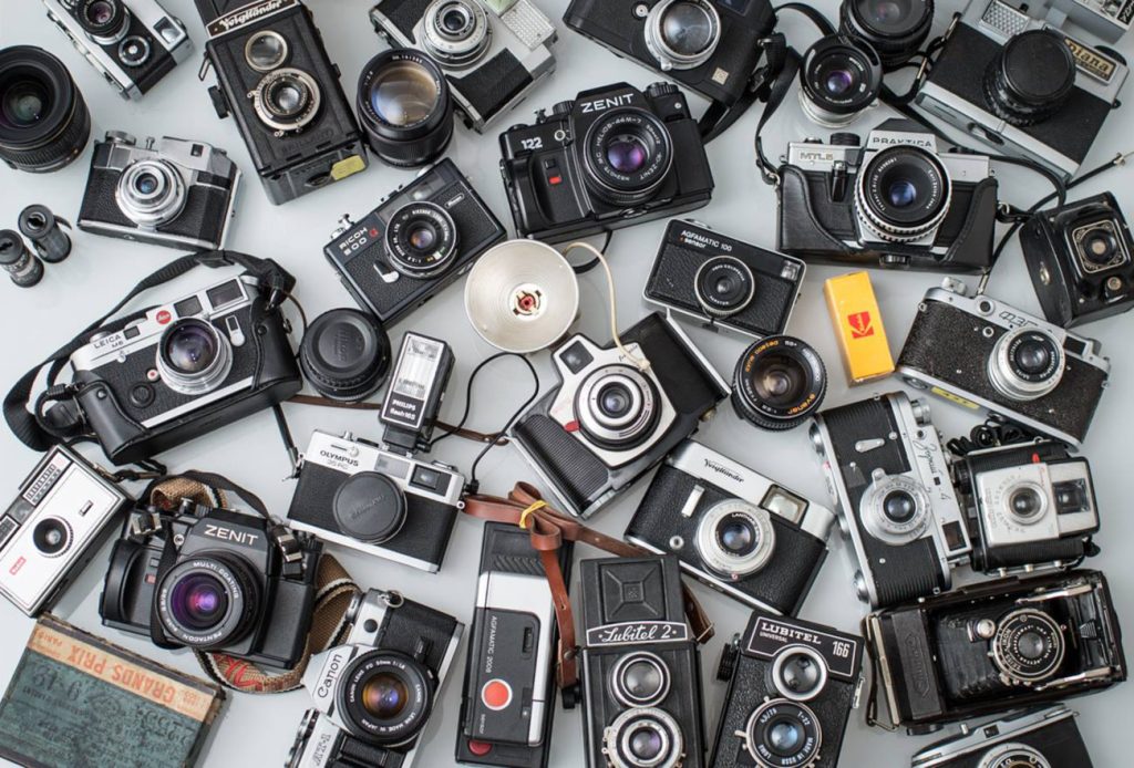 fotocamere di vario tipo disposte su un tavolo